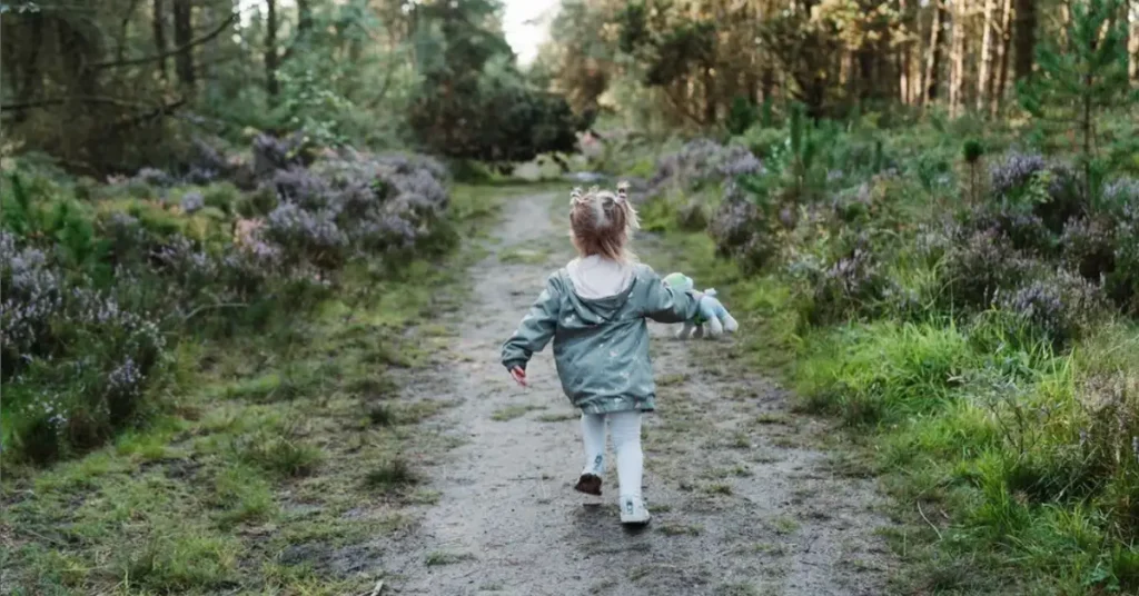young child running in a forest