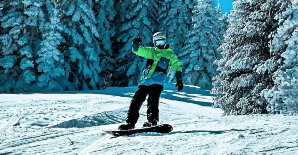 man with green jacket snowboarding
