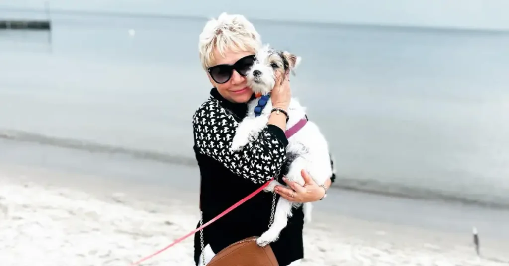 old woman with short hair holding a dog