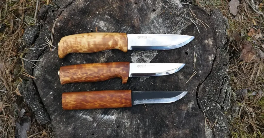 three different knifes on a log