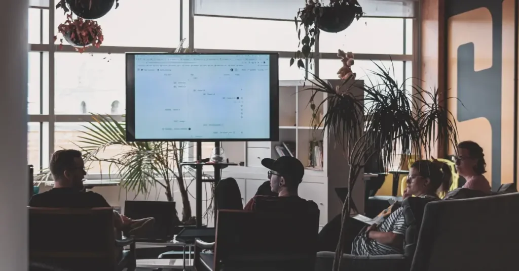 people sitting infront of a tv screen in an office
