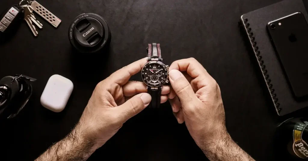 man holding a watch over black surface