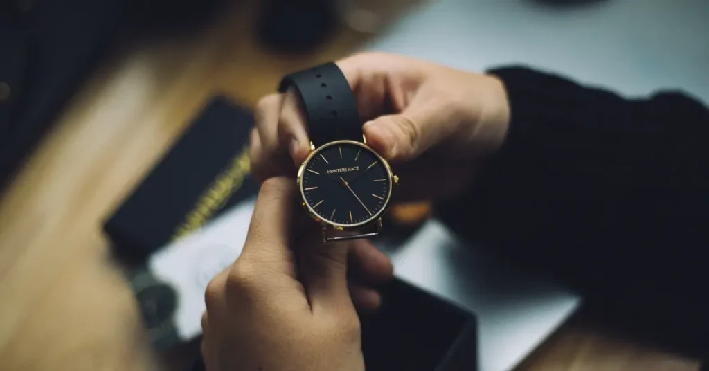 young man holding a black watch