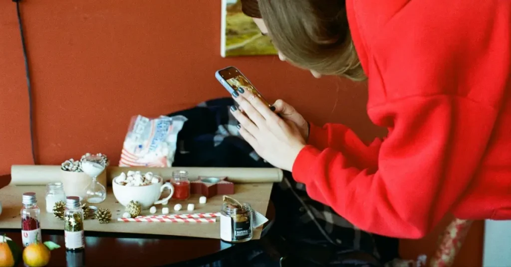 young woman with mobile phone in her hand sitting on a table