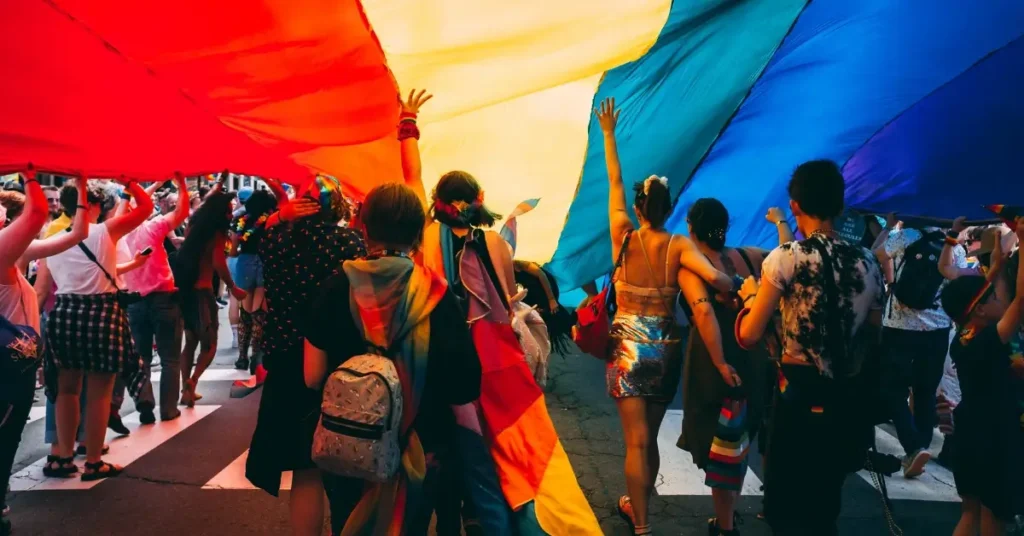 gay people under a big pride flag