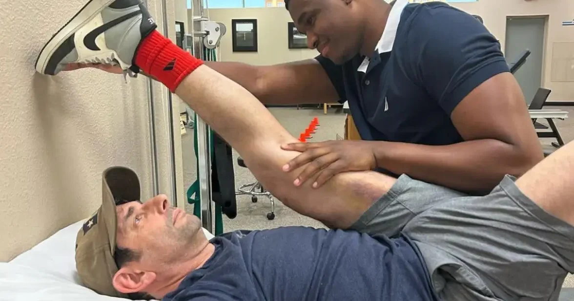 young physical therapy student treating an older man