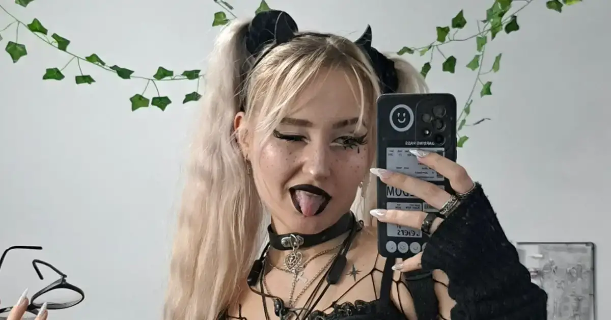 young goth girl with blonde hair looking in the mirror