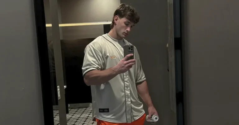 young male powerlifter posing infront of the mirror with his shirt on
