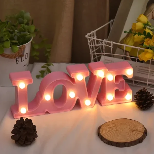 Valentines Room Decor love word written shining in pink on a desk